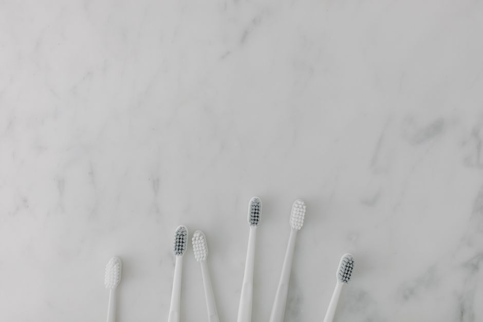 Photo by Tara Winstead on Pexels Five minimalist toothbrushes arranged on a marble surface, perfect for dental care themes. - Photo by Tara Winstead on Pexels