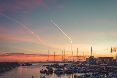 Free Yachts on river under sunset sky in city port Stock Photo