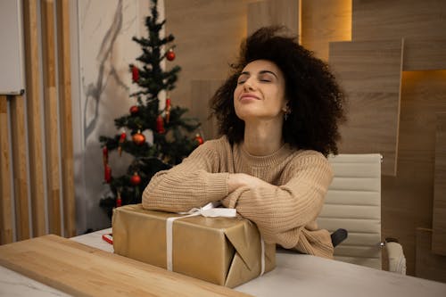 Happy Woman Sitting at Desk with Present