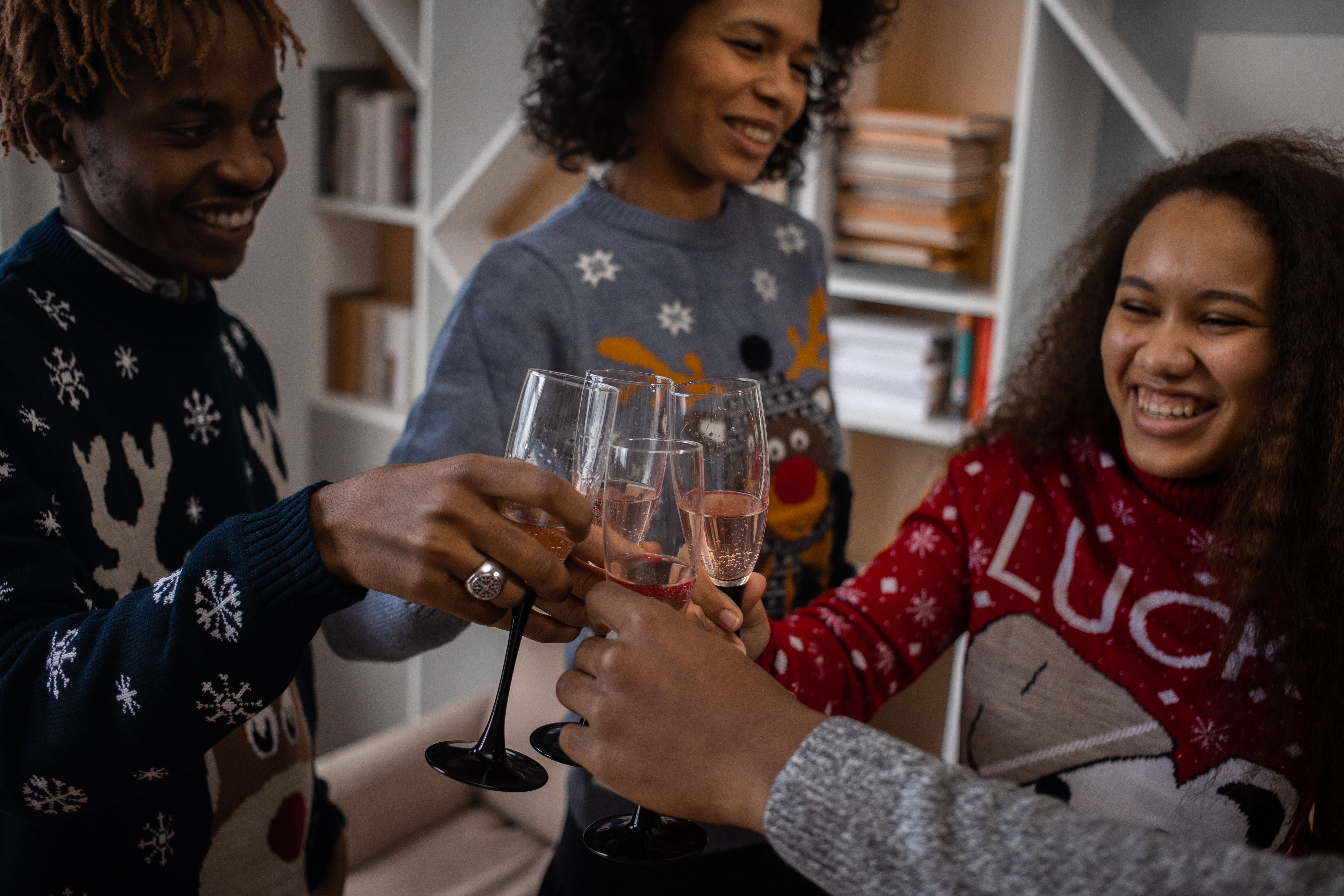 A cheerful group of friends toasting during a holiday celebration indoors.