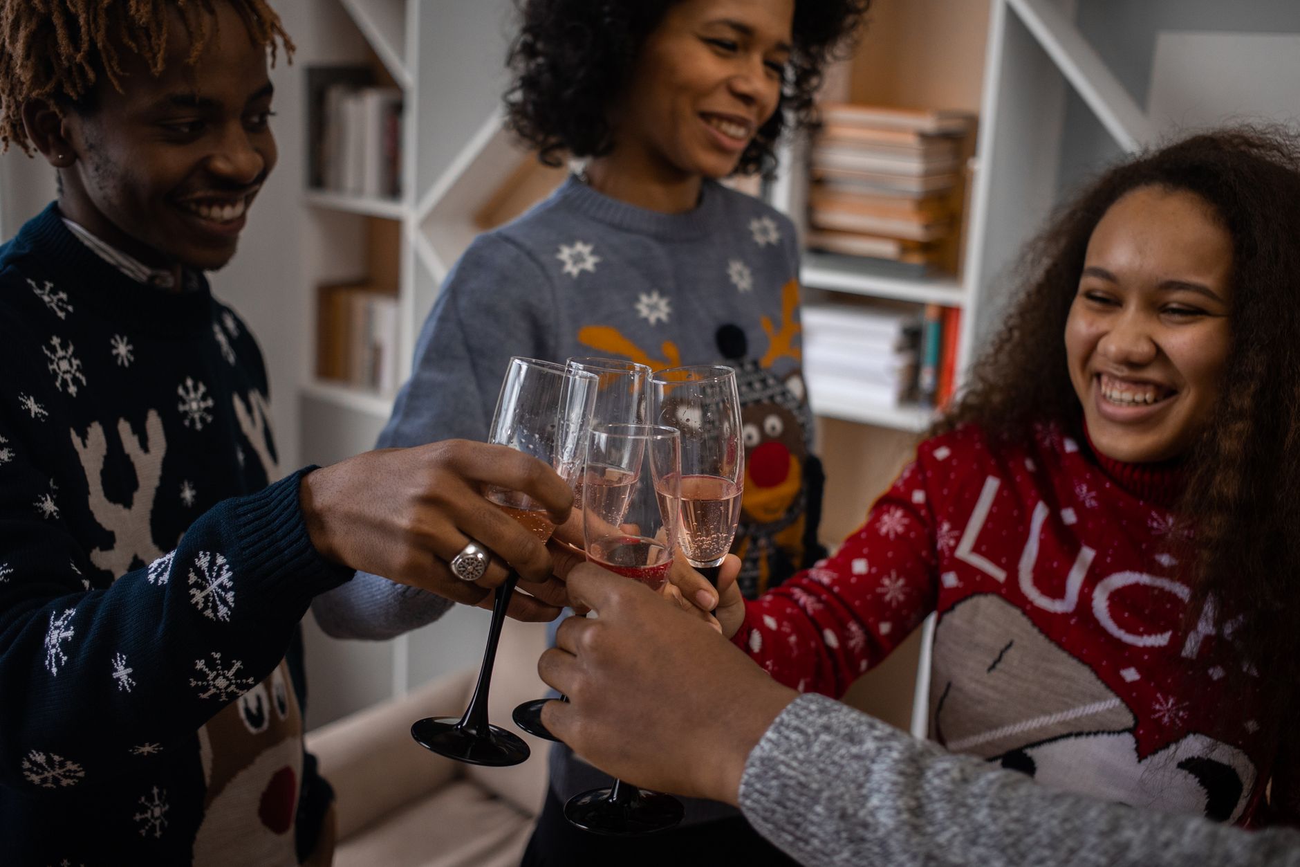 A cheerful group of friends toasting during a holiday celebration indoors.
