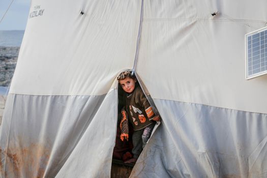 Poor ethnic boy in dirty tent