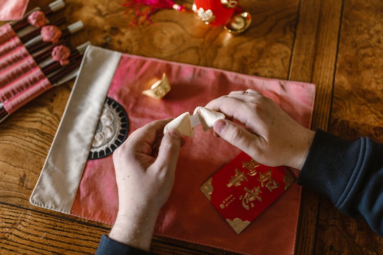 A Person Opening A Fortune Cookie