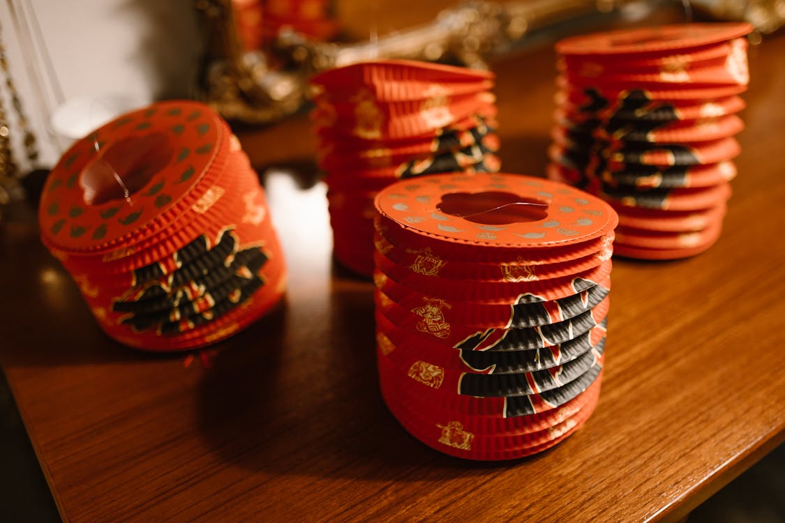 Decorative Chinese New Year lanterns with traditional patterns displayed on a wooden table.
