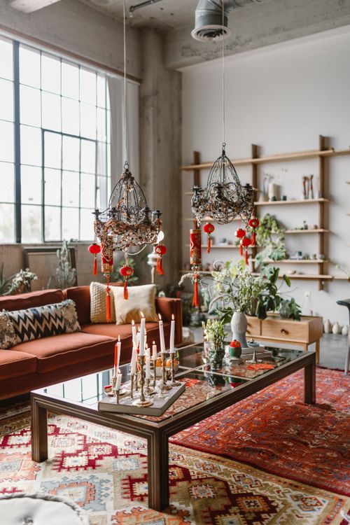 Free Cozy living room with red decor, candles, and hanging chandeliers. Stock Photo