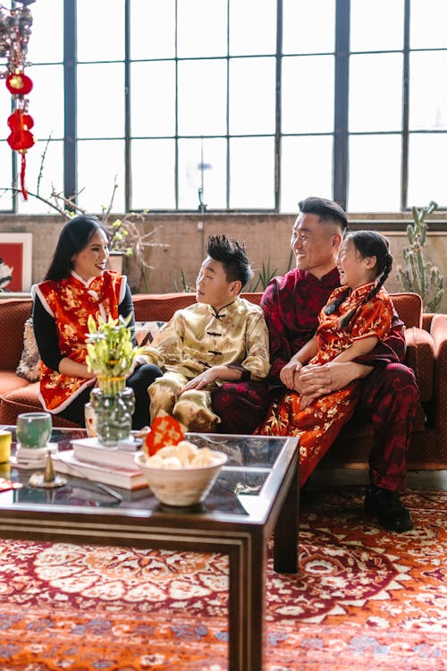 Free Family Wearing Traditional Clothes Sitting in the Living Room Stock Photo