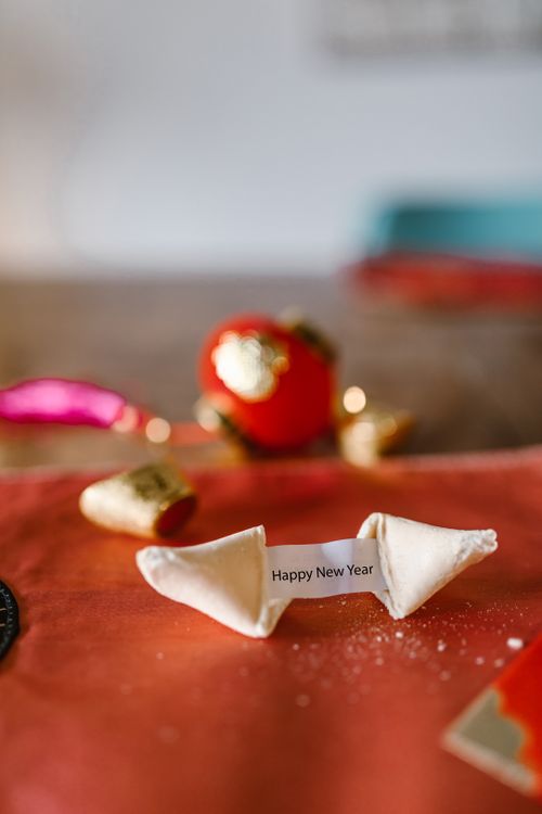 Free A fortune cookie with a 'Happy New Year' message on a festive table setting. Stock Photo