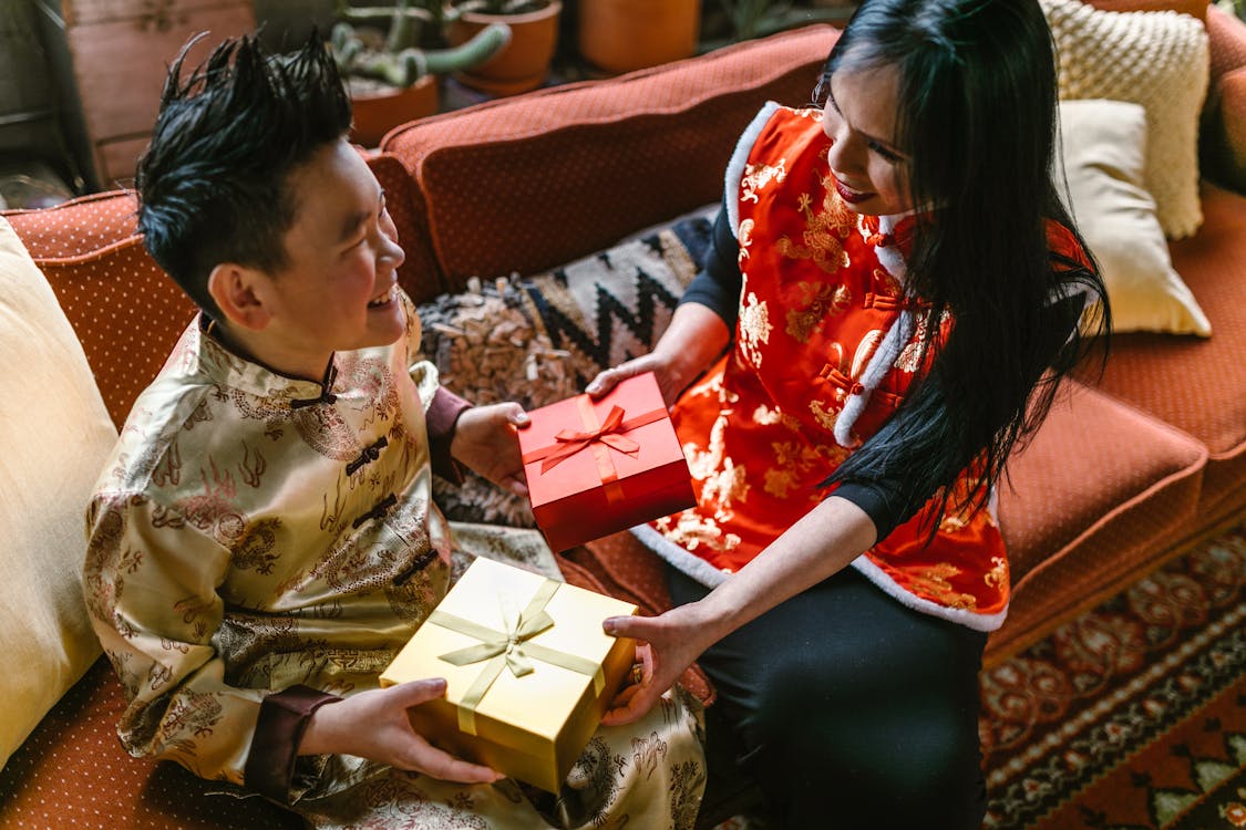 Mother and son in traditional Chinese clothing exchanging gifts