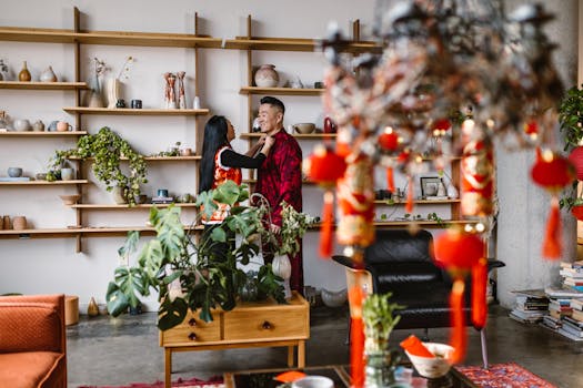 A couple celebrating Chinese New Year in a beautifully decorated room with traditional red ornaments.