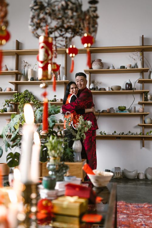 Free A couple embracing in traditional clothes surrounded by decorations for a festive celebration indoors. Stock Photo