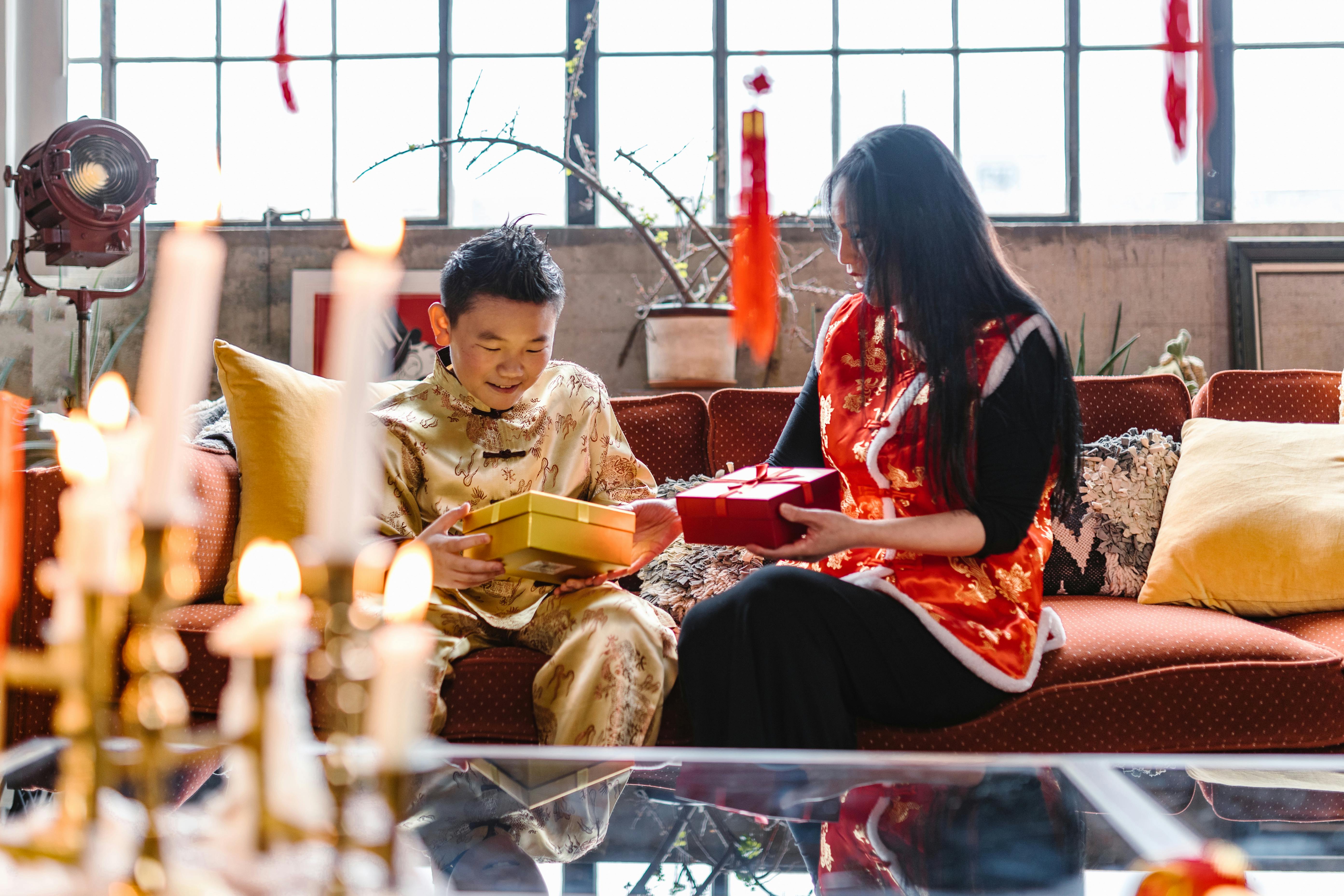 a boy and woman holding a gift