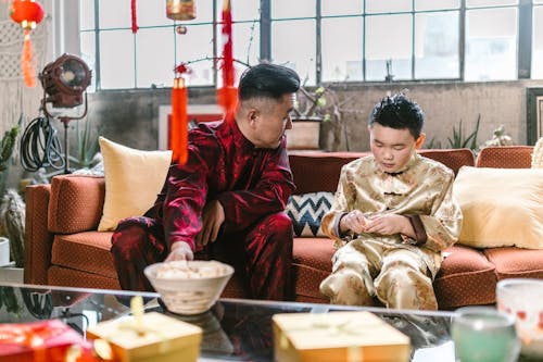 A Boy Sitting on Couch Opening a Fortune Cookie