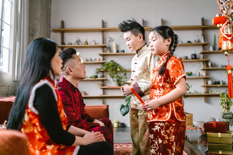 Boy And Girl Standing In Front Of Their Parents