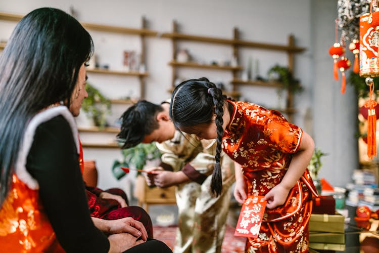 Boy And Girl In Traditional Clothes Bowing Their Heads