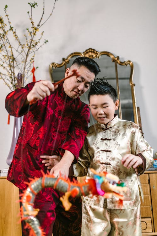 An Elderly Man Teaching his Grandson How to Play with a Puppet