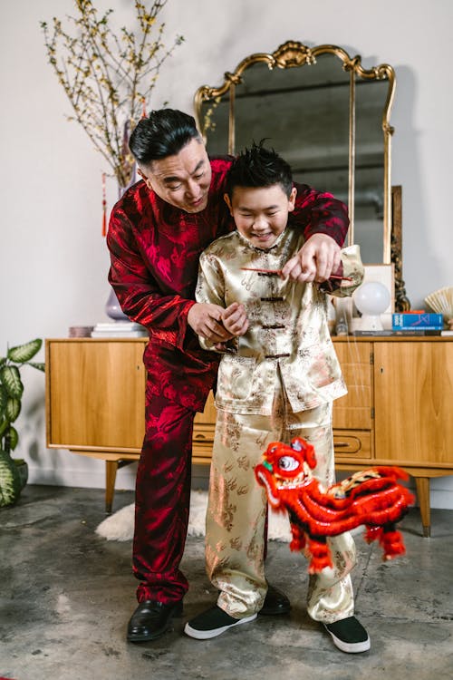 An Elderly Man Teaching his Grandson How to Play with a Puppet