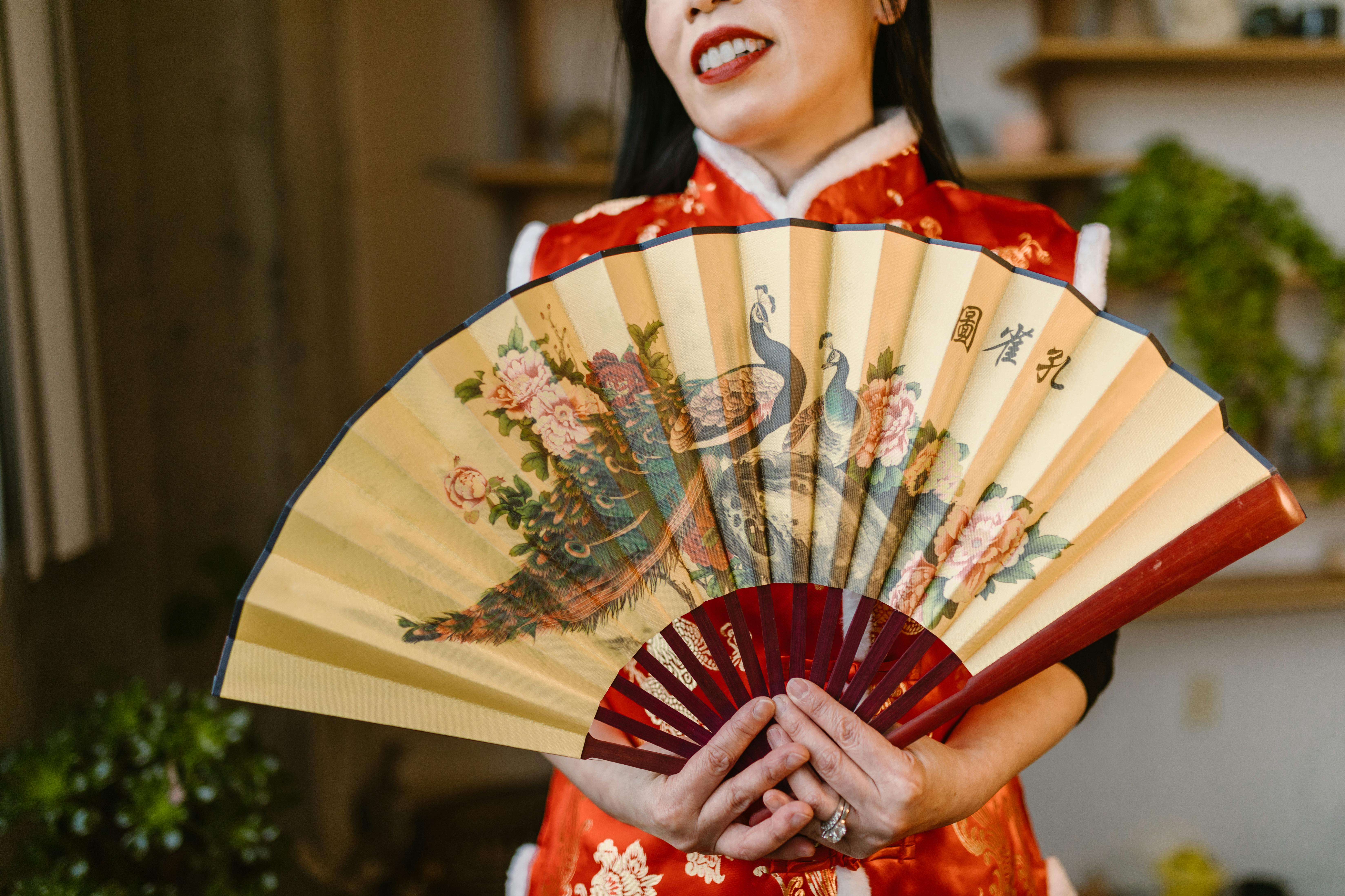 shallow focus of a woman holding a hand fan