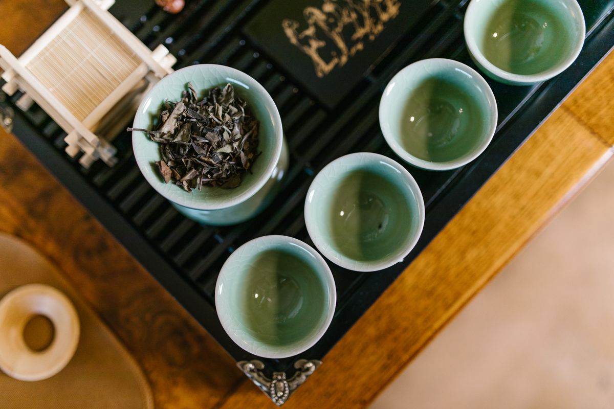 A refined overhead arrangement of tea leaves and teacups