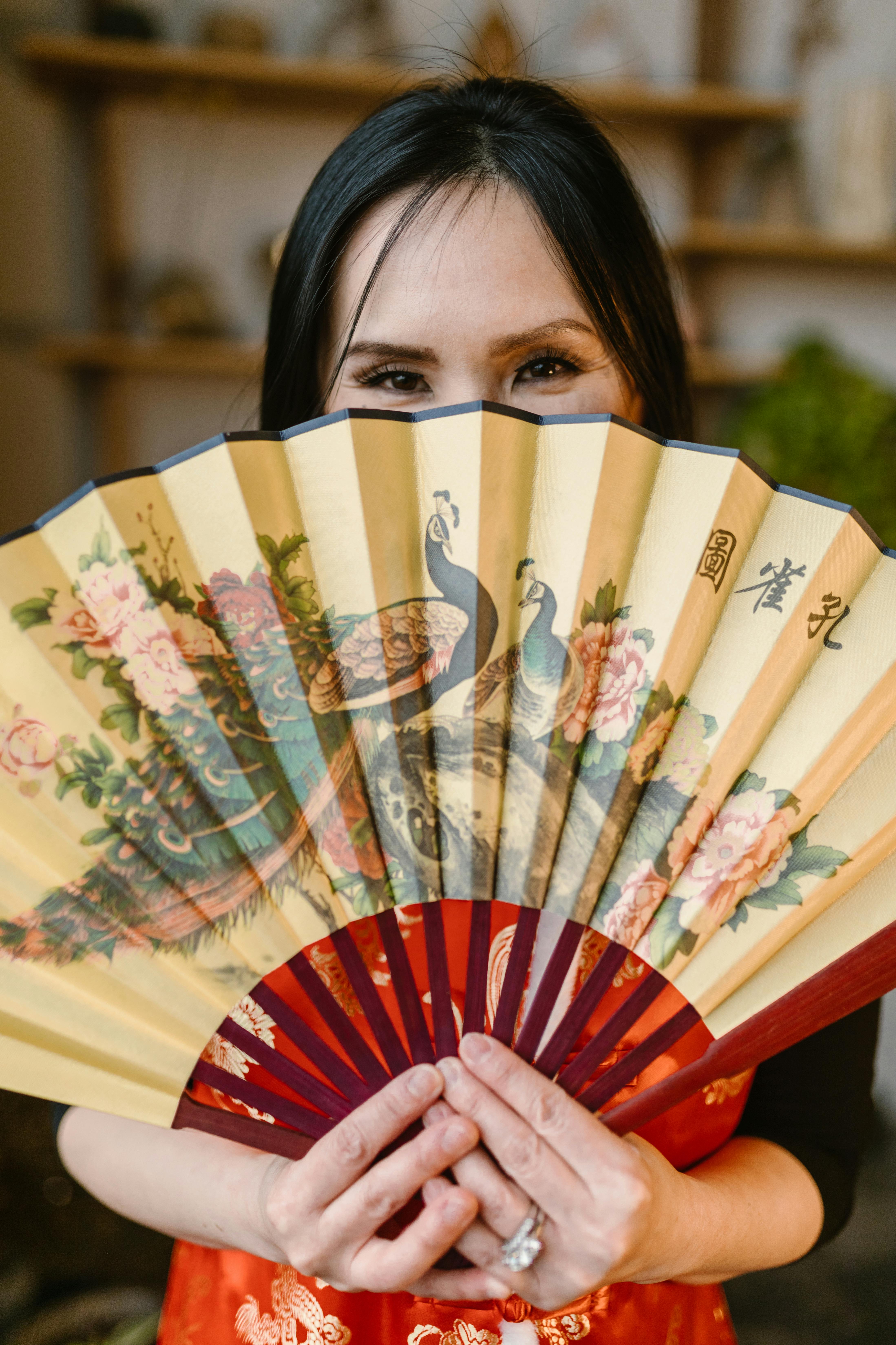 a person holding an asian fan