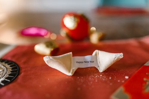 Free Close-up of a fortune cookie with 'Happy New Year' message on a decorated festive table. Stock Photo