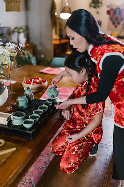 
A Mother Pouring Tea with Her Daughter