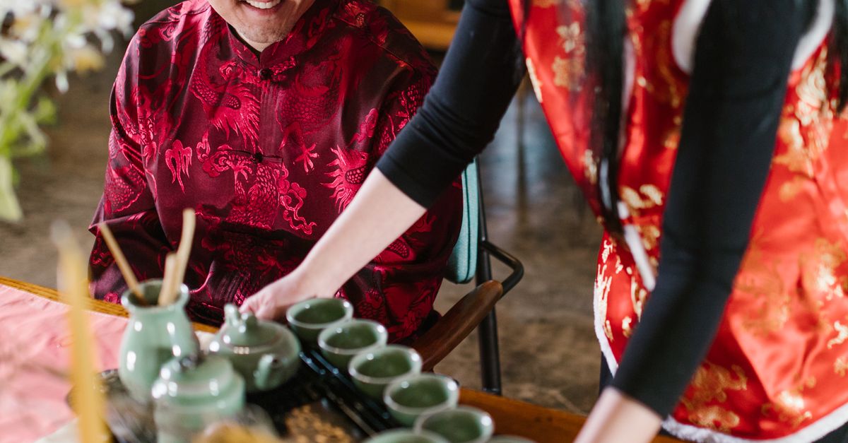 Seiving Tea A Woman Serving a Tea Set · Free Stock Photo