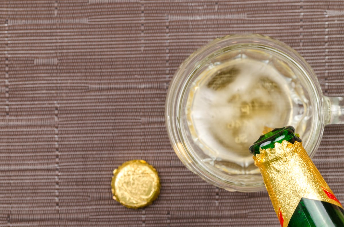 Person selecting healthy bottled drinks from a grocery store refrigerator shelf