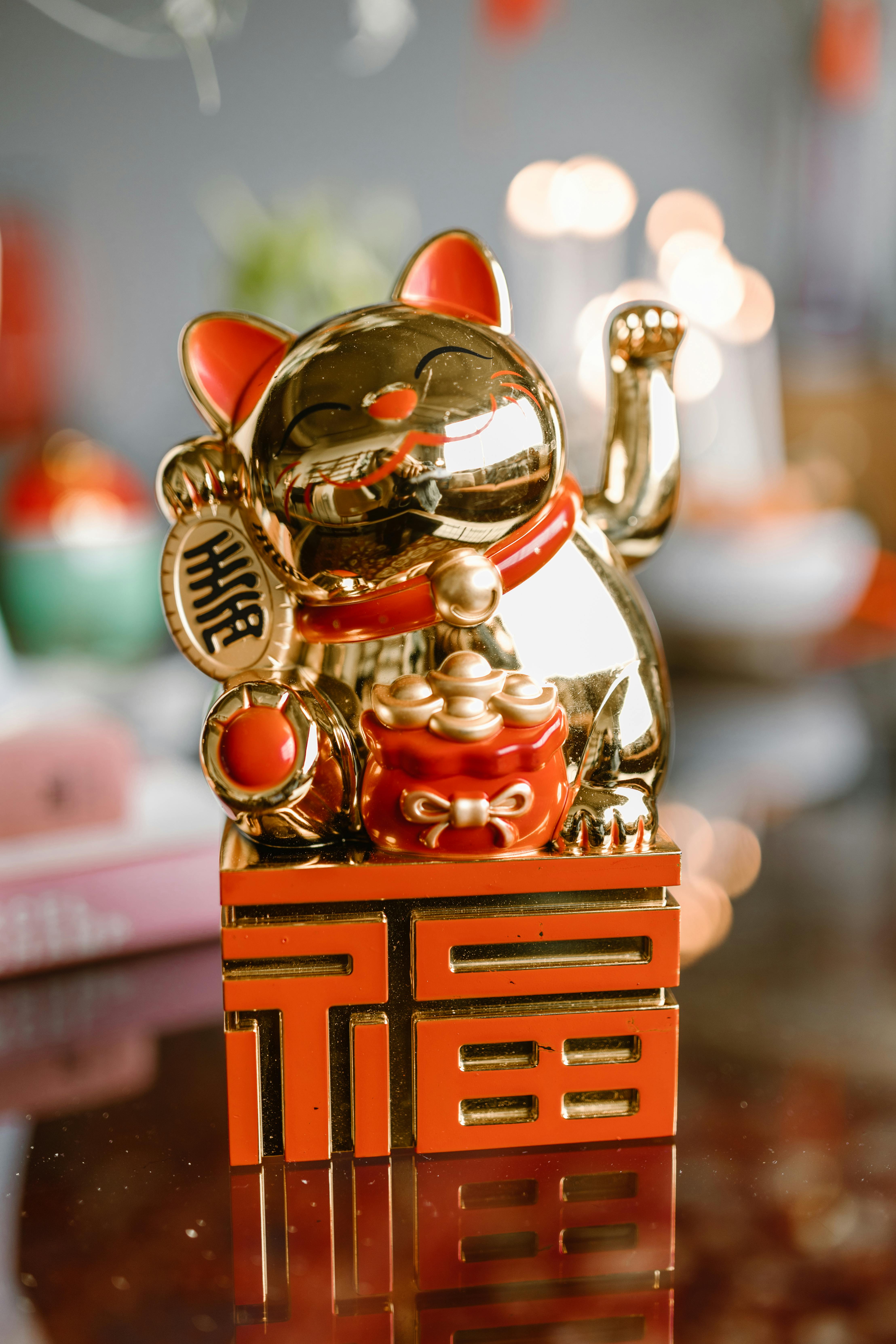a gold and red cat figurine