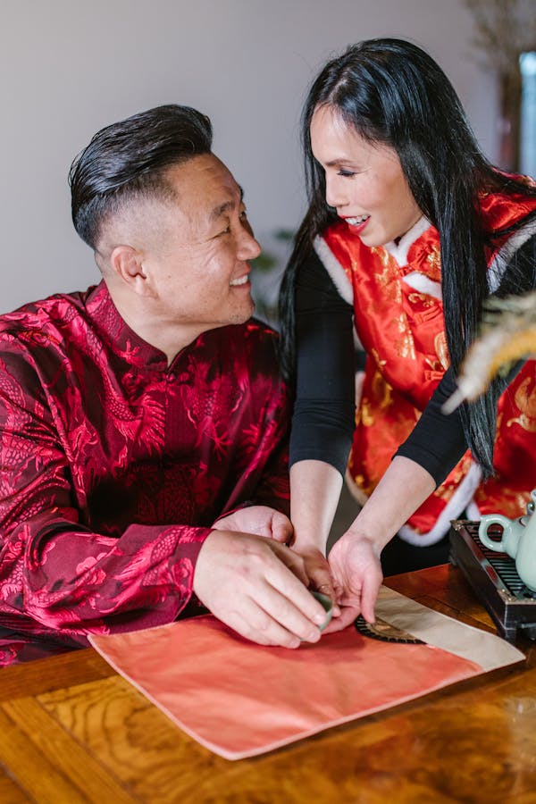 Man and a Woman in Red Traditional Wear Looking at Each Other