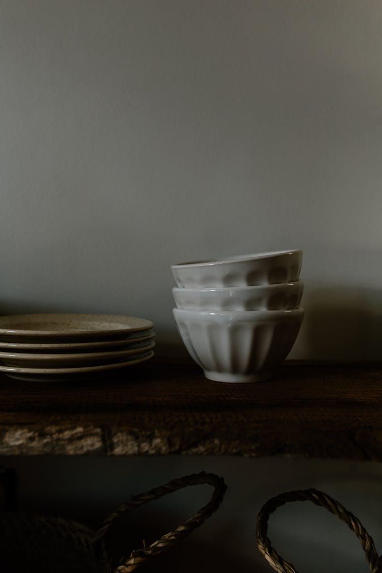 
A Close-Up Shot Of Bowls And Plates On A Wooden Shelf