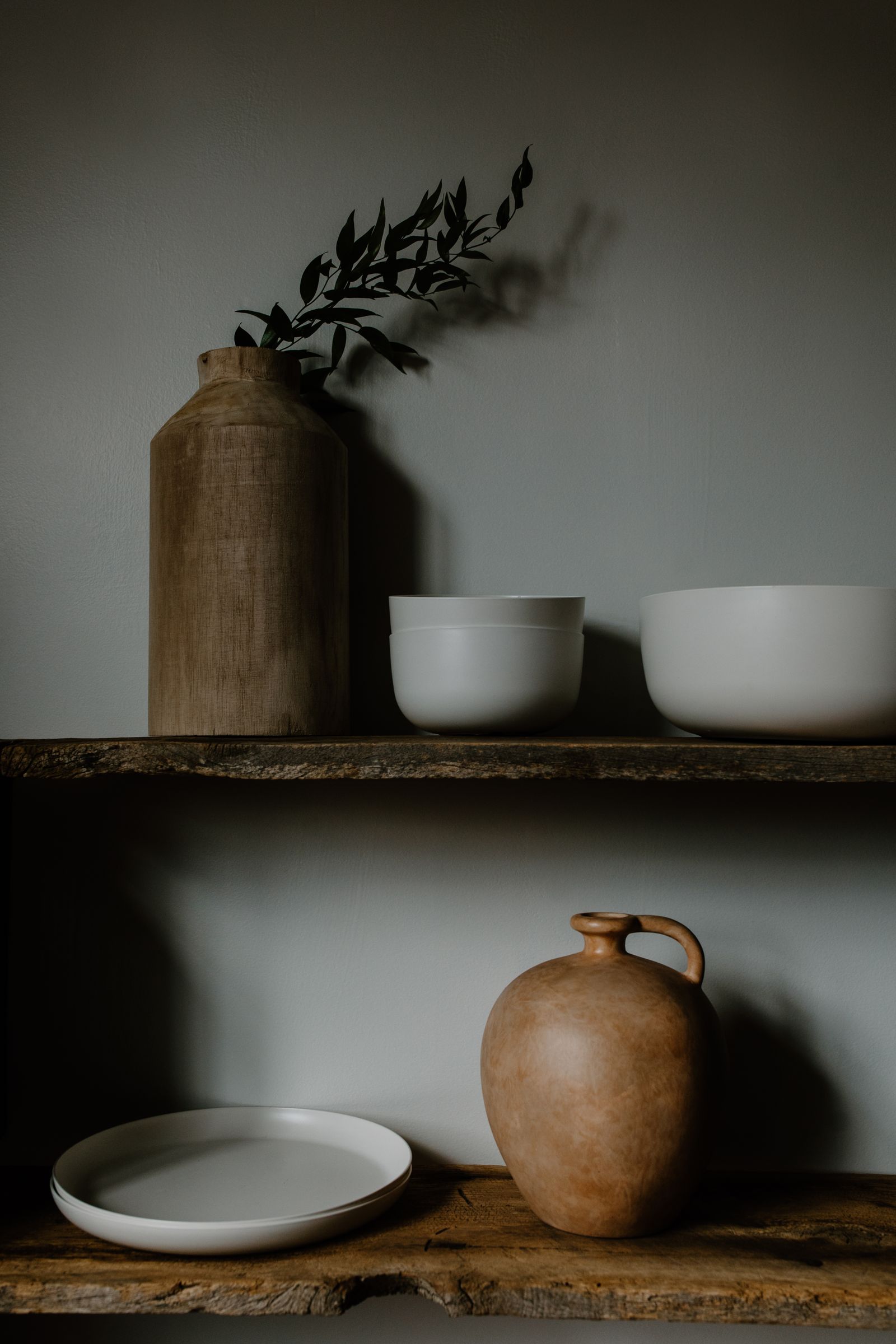 minimalist room design 2026 handmade ceramics on wooden shelves wabi-sabi