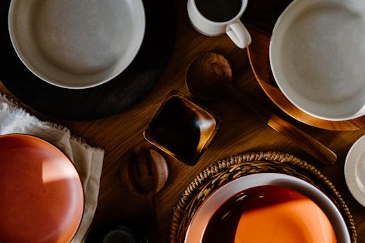 Aesthetic flat lay of a minimalist table with ceramics, wood, and woven elements.