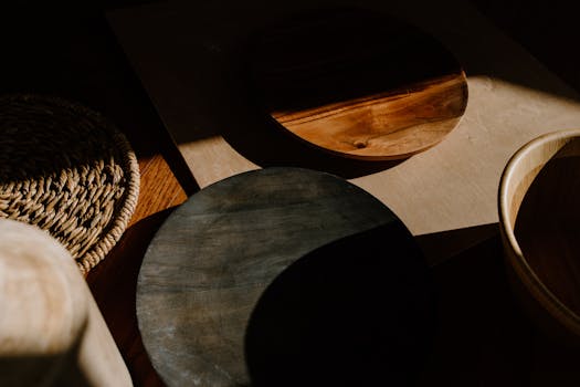 Artistic arrangement of wooden bowls showcasing shadows and texture in a minimalist setting.