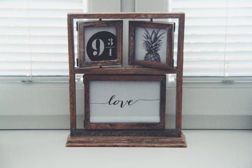 Brown Wooden Picture Frames Beside Window