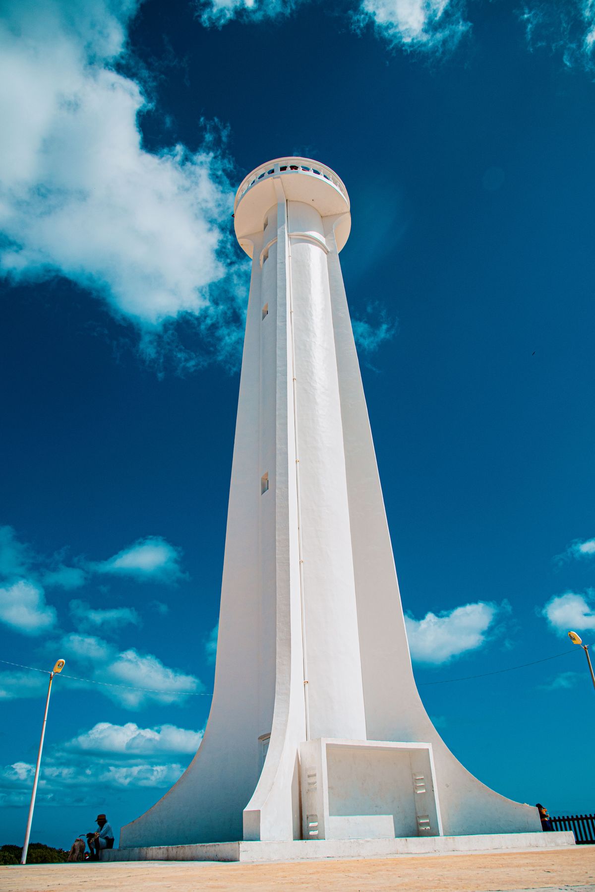 Stunning view of Mahahual lighthouse against a bright blue sky, perfect for travel inspiration.