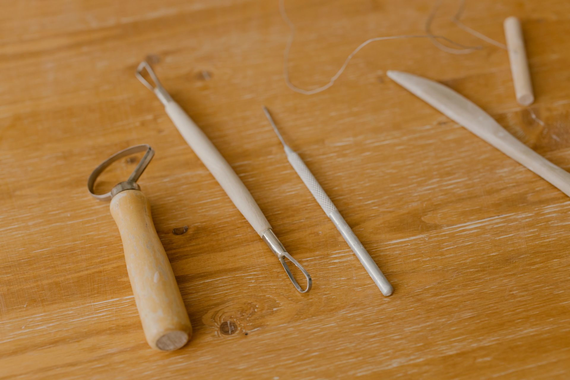Close-up of various wood carving tools on a wooden surface, ideal for DIY projects.