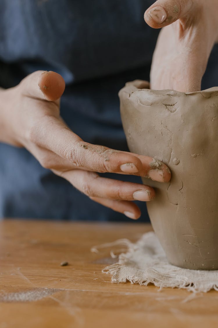 Hands Of A Person Sculpting A Clay Pot