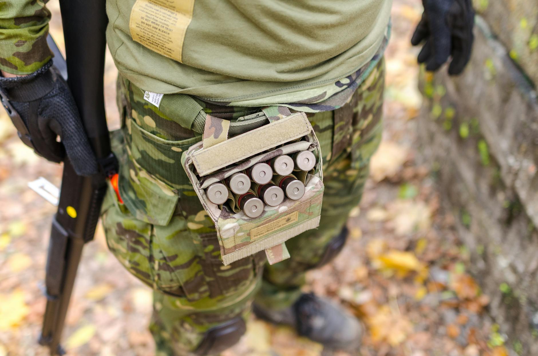 Man in a camouflage holding a shotgun