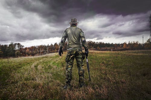 Homem Com Roupa Camuflada Segurando Uma Espingarda