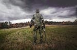 Man in Camouflage Suit Holding Shotgun