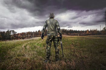 Man in Camouflage Suit Holding Shotgun