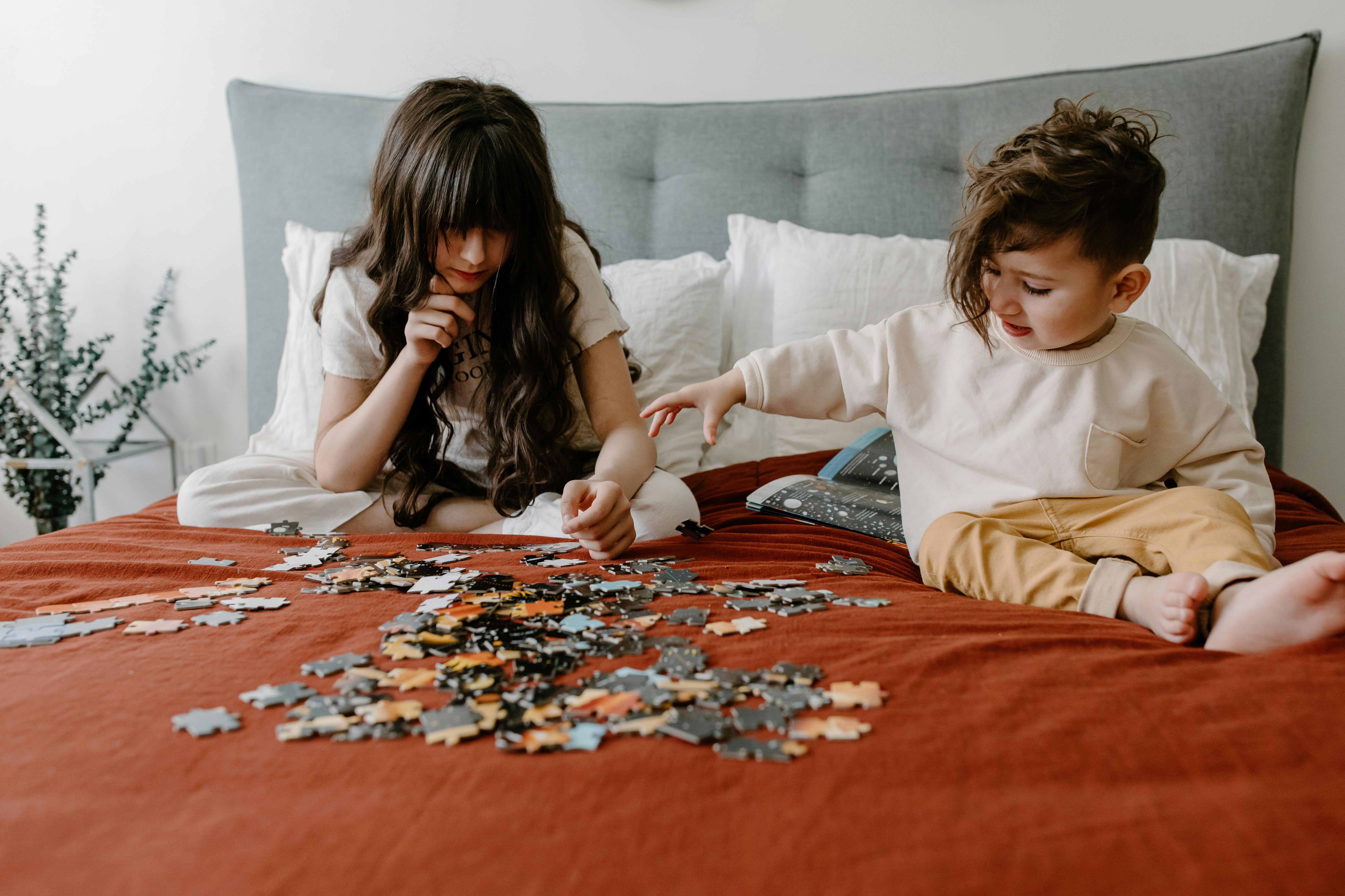 children with puzzles on a bed