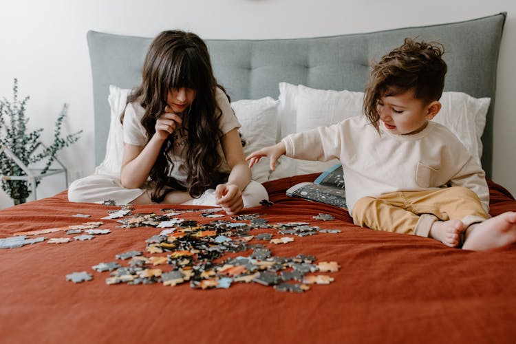 Children With Puzzles On A Bed