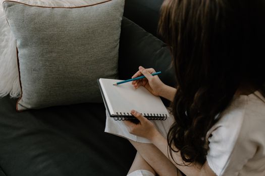 A Person Writing in a Notebook