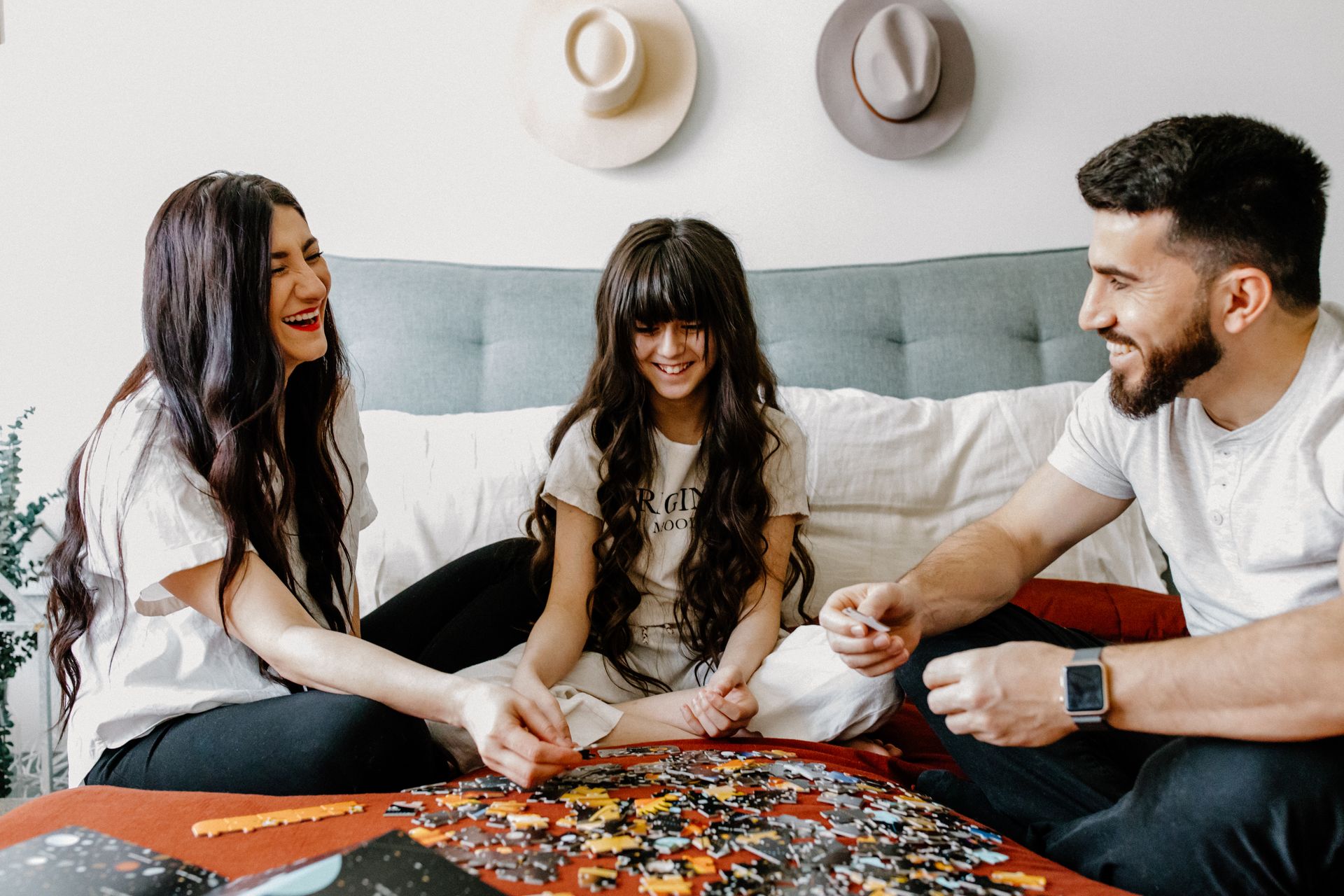 A Family Sitting on Bed Putting the Puzzle Pieces Together