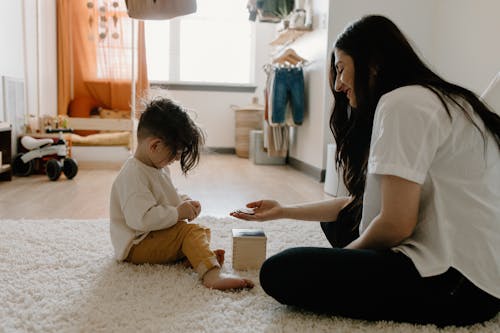 A Little Boy Playing with an Educational Toy with his Mom