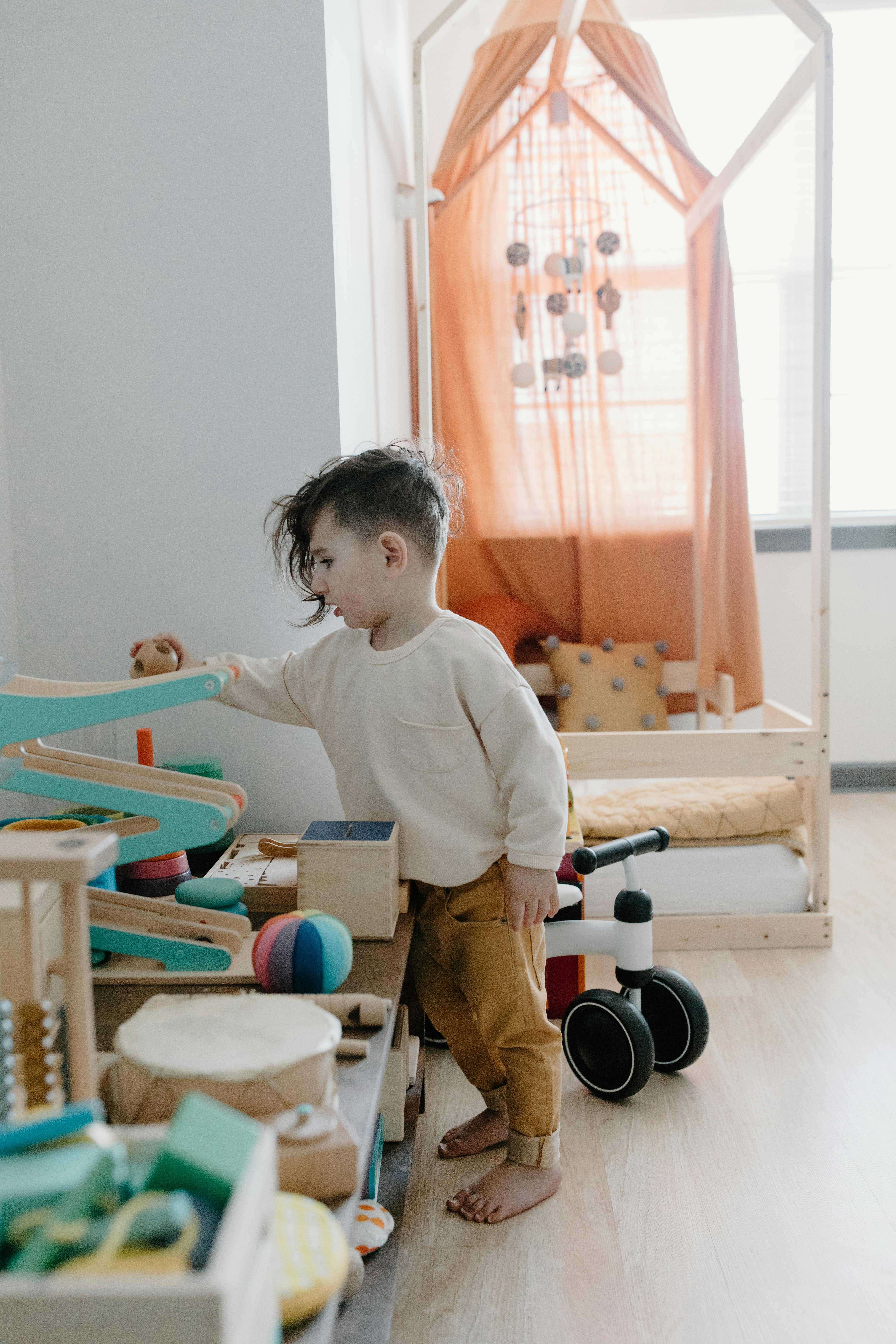 a boy playing beside the bed