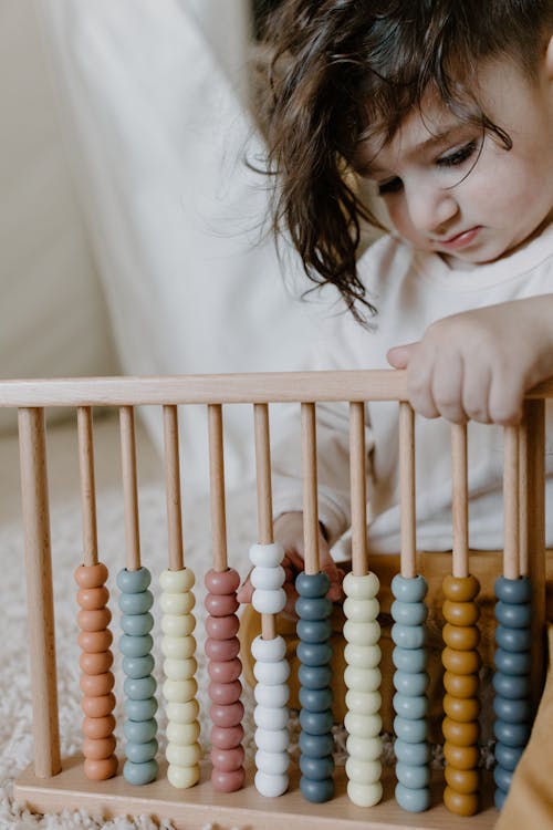 A Cute Baby Holding an Abacus