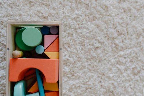 Free A set of colorful wooden blocks on a carpet, ideal for children's creative play. Stock Photo