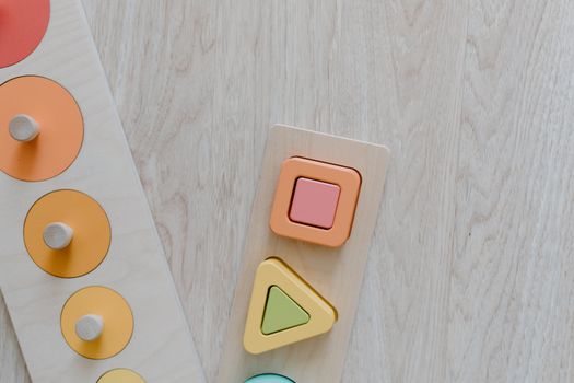 Top view of a wooden kids toy puzzle with colorful geometric shapes for educational play. — photo by Tara Winstead